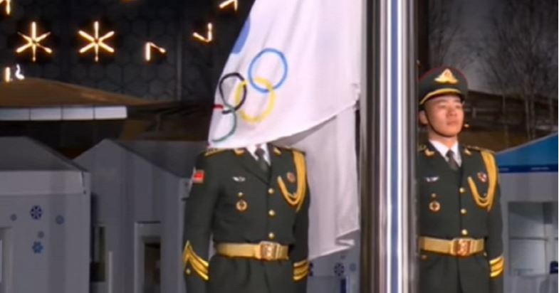 Az olimpiai zászló alá ragadt a katona feje: a videó megörökítette meglepő reakcióját